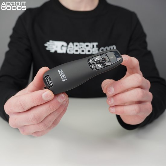 Hand houdt compacte zwarte presentatiepointer met knoppen en Adroit Goods logo vast
