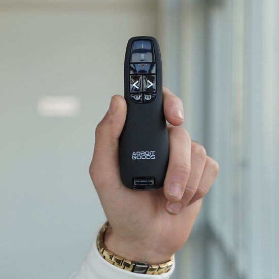 Hand houdt zwarte afstandsbediening met knoppen en logo Adroit Goods zichtbaar