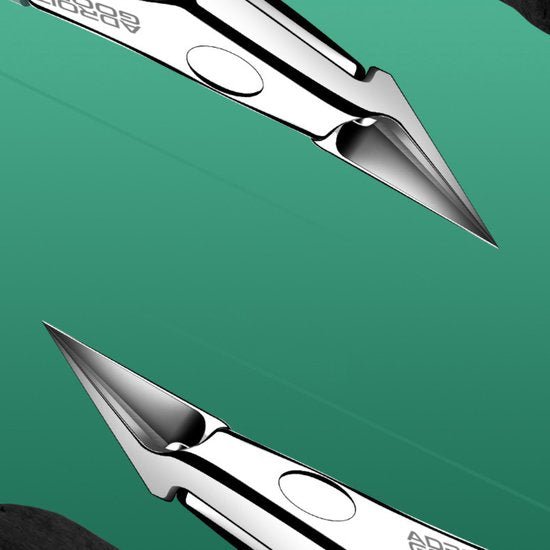 close-up van twee scherpe metalen pennen tegen een groene achtergrond met merknaam zichtbaar