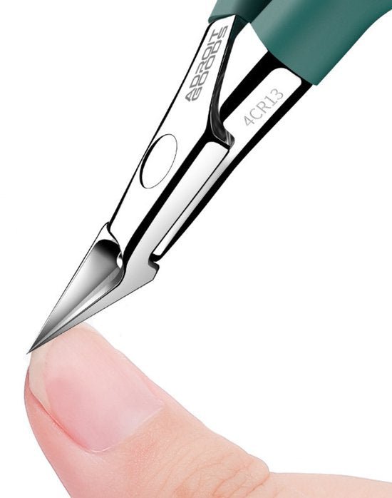 Nauwkeurige metalen nagelknipper met scherpe snijkanten dicht bij een duimnagel