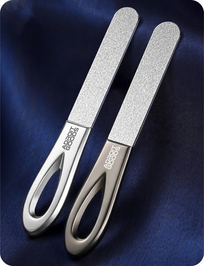 Twee metalen nagelvijlen met ergonomische handgrepen liggend op een blauwe stof achtergrond