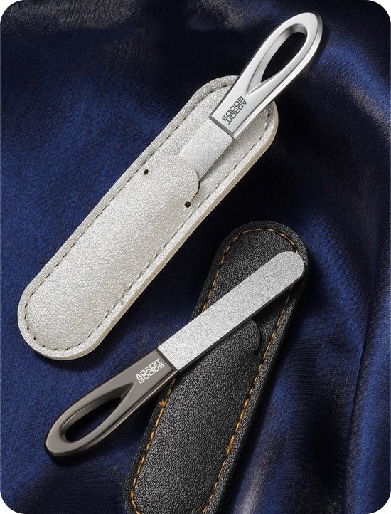 Twee metalen nagelvijlen met leren hoesjes op een donkerblauwe stofachtergrond