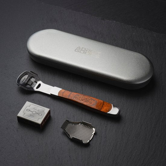 RVS flesopener met houten handvat, scheermesje en metalen houder naast metalen etui