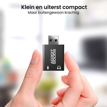 Hand houdt een kleine zwarte USB-adapter met witte tekst Adroit Goods vast