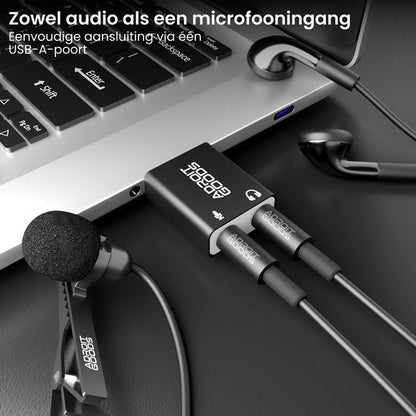 Laptop met aangesloten adapter, microfoon en oordopjes op zwart oppervlak