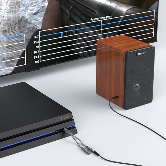 Zwarte speelconsole naast houten luidspreker met verbonden kabels op witte ondergrond