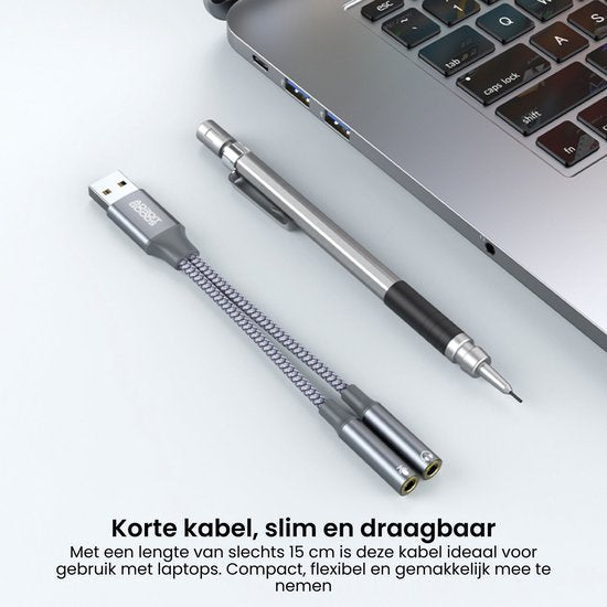 korte usb-kabel met stoffen mantel naast laptop en metalen mechanische potlood