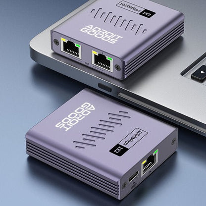 Twee paarse netwerkadapters met Adroit Goods-logo naast een laptop met USB-C-poort.