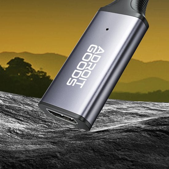 grijze metalen draagbare elektronische apparaat met Adroit Goods logo tegen natuuropzicht