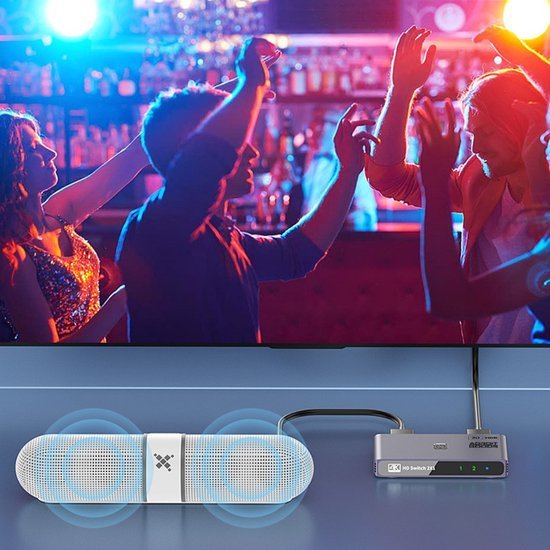 Muzieksysteem met speakers en een switch, zichtbaar geluidsgolven en mensen die dansen in sfeervol clublicht