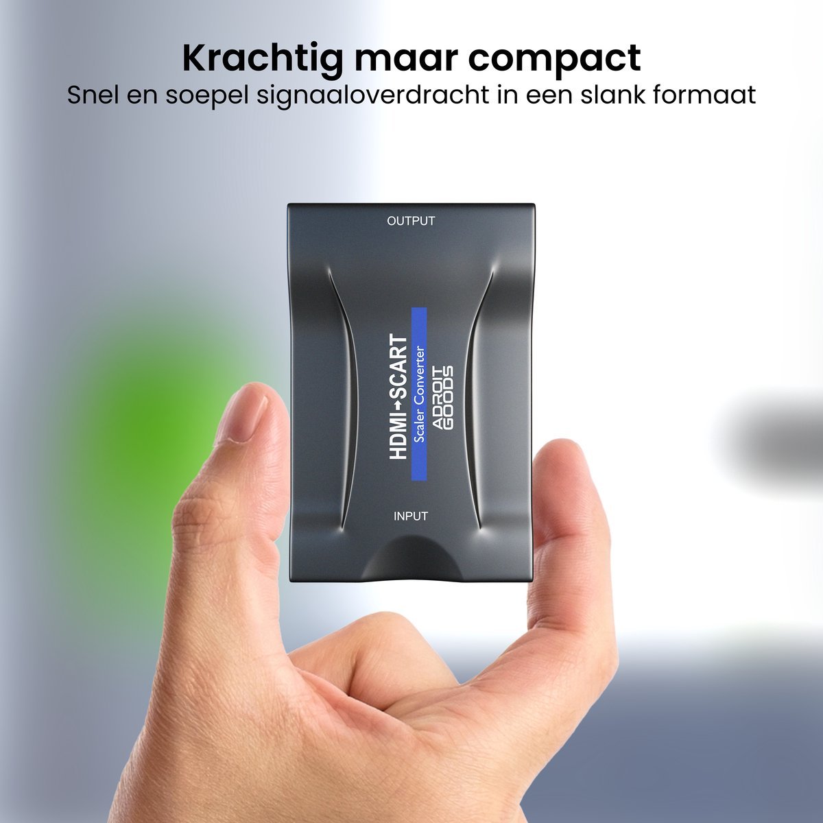 Hand die een compacte zwarte HDMI naar SCART converter tussen duim en wijsvinger houdt