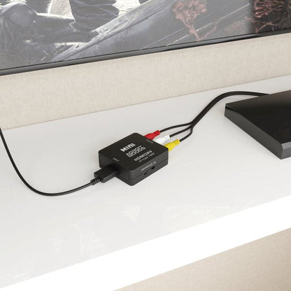 zwarte mini video converter met rood, geel en wit AV-kabels op een witte kast