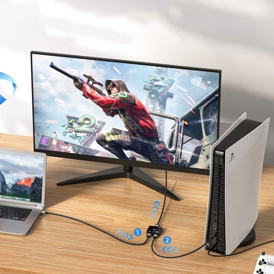 Speelconsole verbonden met monitor en laptop op houten bureau voor gaming setup