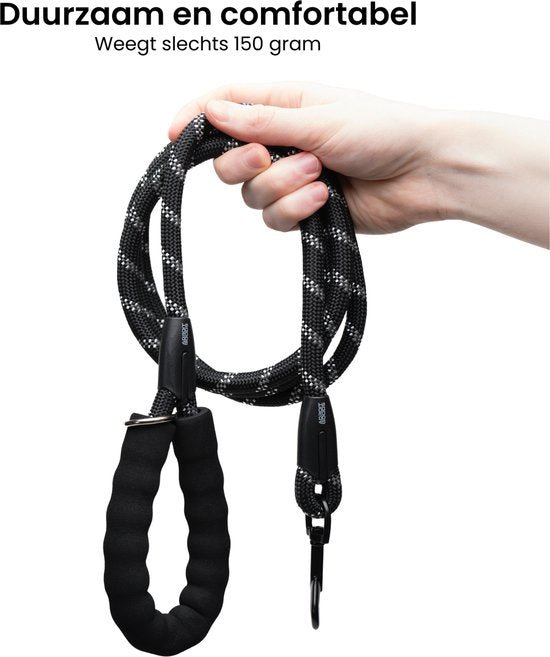 Hand houdt duurzame zwarte hondenriem met zachte grip en metalen haak tegen witte achtergrond