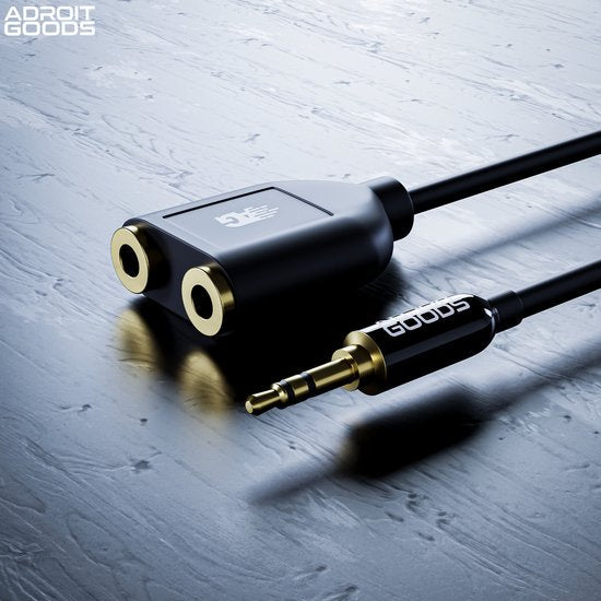 zwarte kabelsplitter met twee vrouwelijke en één mannelijke 3,5mm audioaansluiting op grijze ondergrond