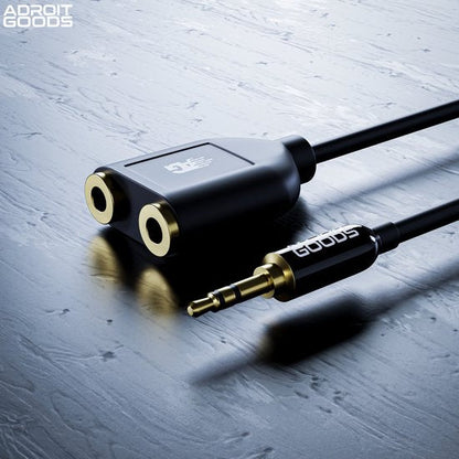 zwarte kabelsplitter met twee vrouwelijke en één mannelijke 3,5mm audioaansluiting op grijze ondergrond