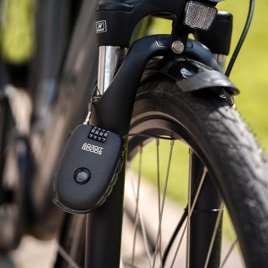 Zwart fietsslot met cijferslot bevestigd aan de voorvork van een fiets met reflectorlampje