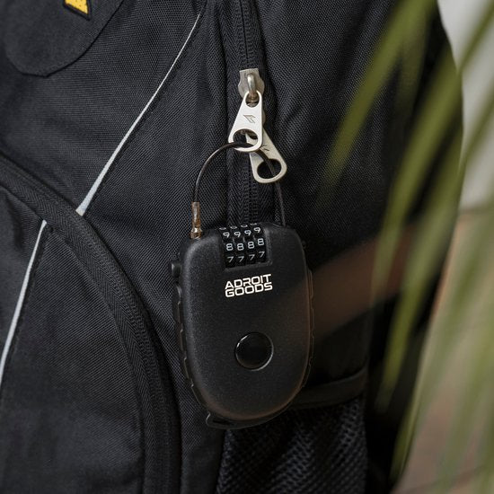 Zwart combinatieslot met cijfers bevestigd aan rits van zwarte rugzak met mesh vakje opzij