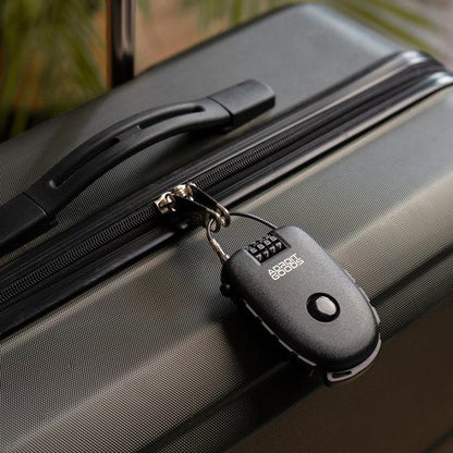 Zwarte combinatieslot bevestigd aan de ritssluiting van een stevige reiskoffer.