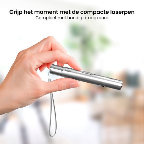 Hand houdt compacte zilveren laserpen vast met draagkoord tegen wazige achtergrond