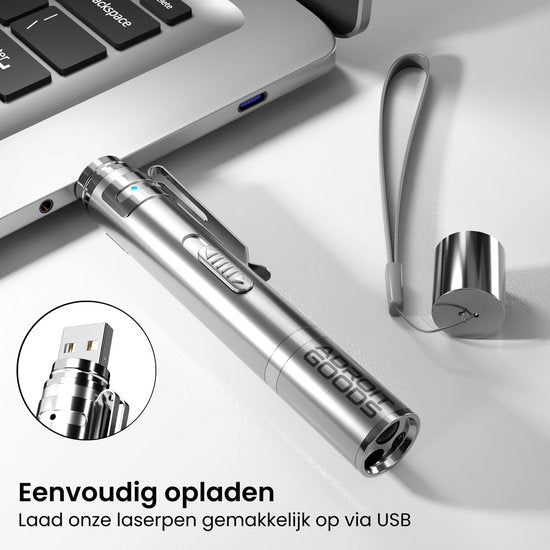Zilverkleurige metalen laserpen met USB oplaadpoort naast laptop en polsbandje