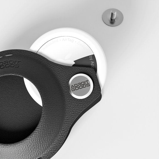 Zwart leren accessoire met metalen logo van AdroitGoods op een witte ondergrond