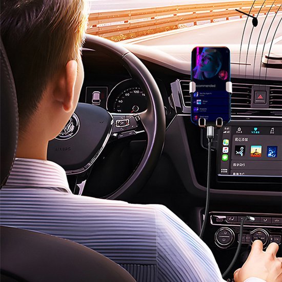 Man rijdt auto terwijl smartphone in houder muziek afspeelt en binnenin zichtbaar is