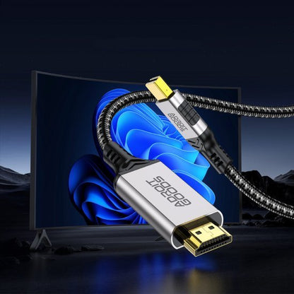 Close-up van een stevig gevlochten HDMI-kabel met metalen aansluitingen tegen een tv-achtergrond.