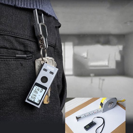 sleutelhanger met digitaal meetinstrument hangend aan broekzak naast meetlint en doos