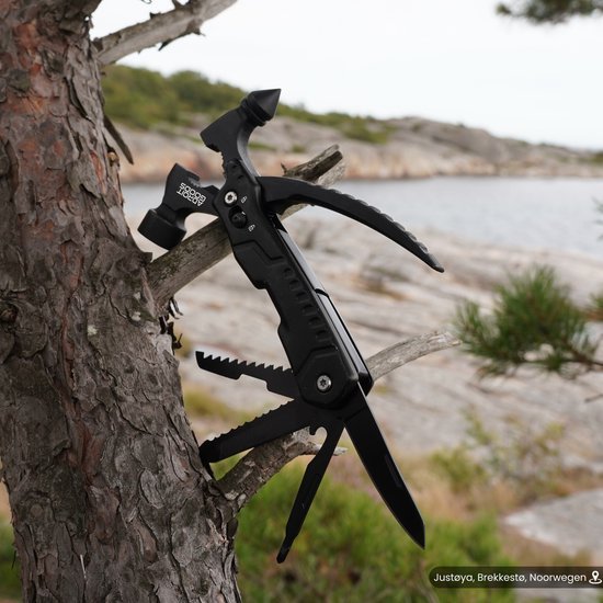 zwarte multifunctionele multitool geïnstalleerd in boomtak met natuurlijke achtergrond