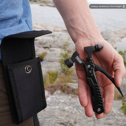 Hand houdt een zwart multitool in een outdoor omgeving naast een open zwarte draagtas