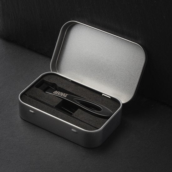 Zwart metalen blikje met schuimvoering en een handgemaakt zwarte AdroitGoods tool erin geplaatst