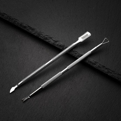 roestvrijstalen tweeledige huidverzorgingsinstrumenten op zwarte achtergrond met textuur