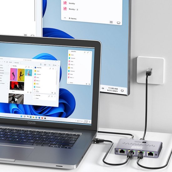 Laptop verbonden met een netwerk switch en een muurstekker in een minimalistische kantooromgeving