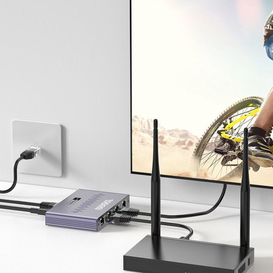 Compact netwerkapparaat met meerdere kabels verbonden aan een televisie en modempunten op bureau