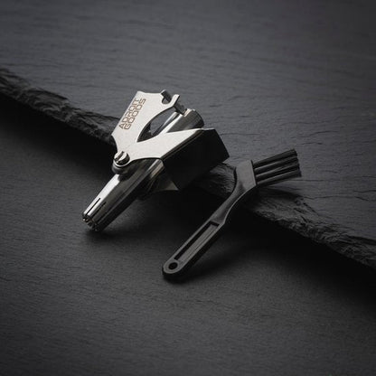 RVS gereedschap met een klein zwart borsteltje op een donkere ondergrond geplaatst