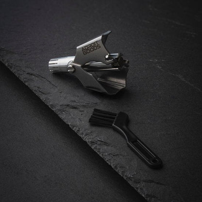 Roestvrijstalen metalen gereedschap met borsteltje op zwarte steenachtige ondergrond