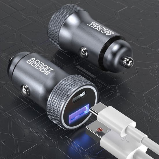 zwarte compacte autolader met USB-poort en aangesloten witte laadkabels op zwarte achtergrond