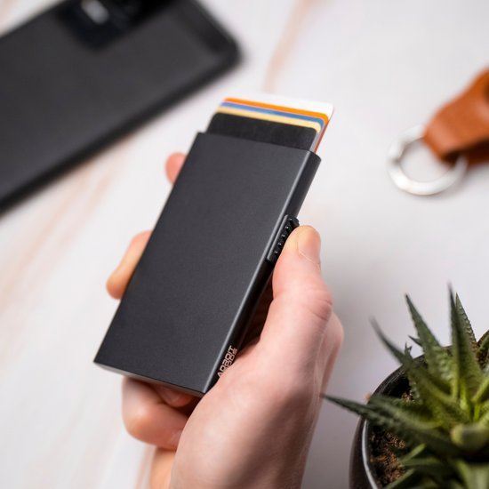 Hand houdt een slank zwart kaart etui waarin meerdere kaarten zichtbaar zijn.