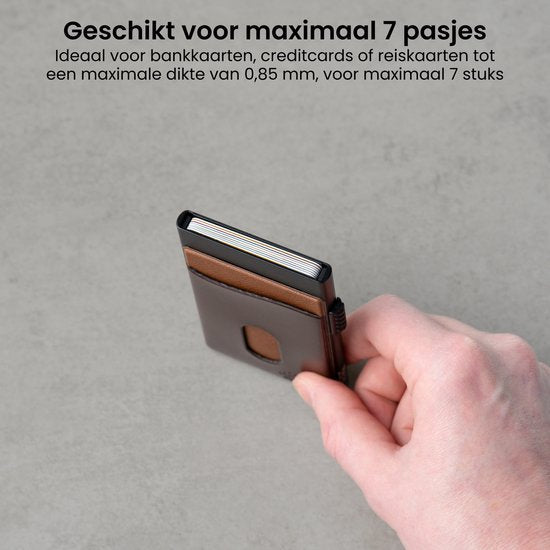 Hand houdt compacte bruine kaarthouder geschikt voor maximaal zeven pasjes vast