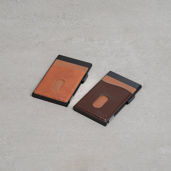 Twee stijlvolle minimalistische portemonnees van leer in verschillende bruintinten op een grijze ondergrond