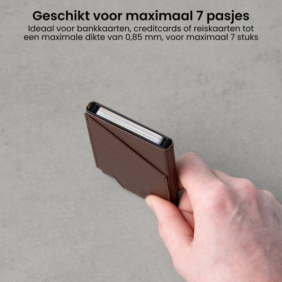 Hand houdt een compact bruin kaarthouder portemonnee met meerdere kaarten erin.