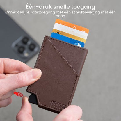 Hand houdt bruine leren minimalistische portemonnee met drie kaarten en schuifknop voor snelle toegang