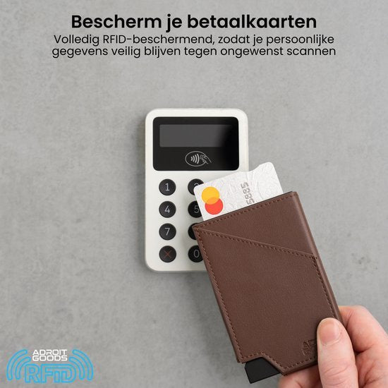 Hand houdt bruin RFID beschermhoesje met bankpas bij betaalterminal voor veilig betalen