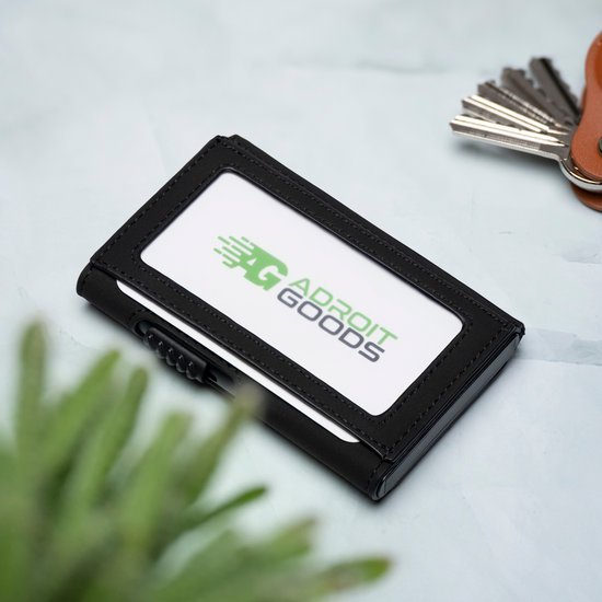 Zwarte pasjeshouder met doorzichtige kaartvenster naast een aantal sleutels op een lichte ondergrond