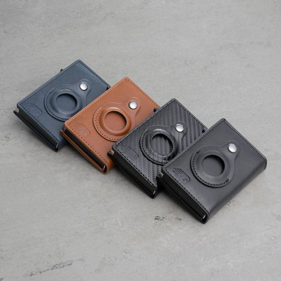 Vier verschillende leren portemonnees in zwart, bruin en grijs met een ronde uitsparing en drukknop detail