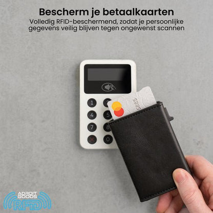 Hand houdt een zwarte RFID portemonnee met een betaalkaart bij een betaalapparaat op een grijze achtergrond