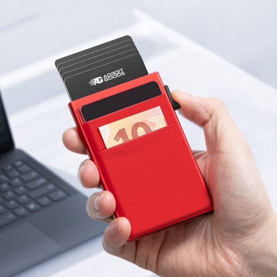 Hand die rode compacte kaarthouder vasthoudt met kaarten en euro bankbiljetten erin.