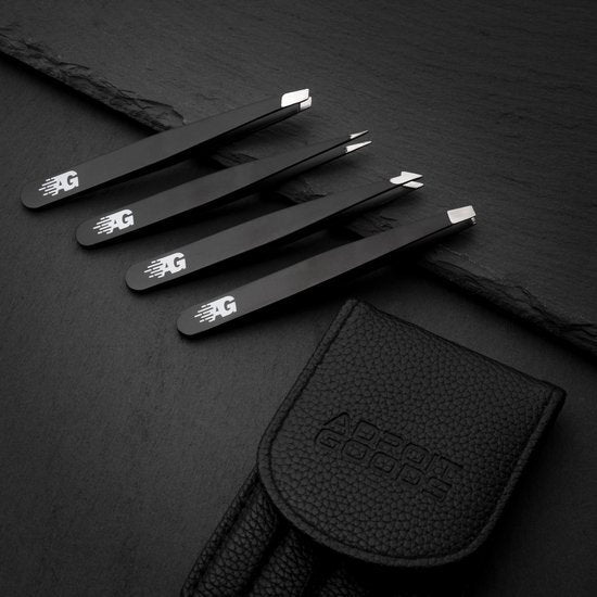 Vier zwarte pincetten met verschillende punten en een zwart leren etui op donkere ondergrond