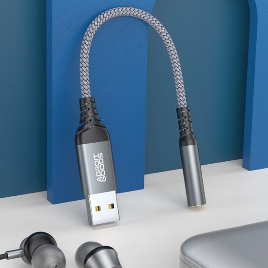 grijs gevlochten USB naar 3,5 mm audiokabel adapter met strakke connectoren naast oordopjes